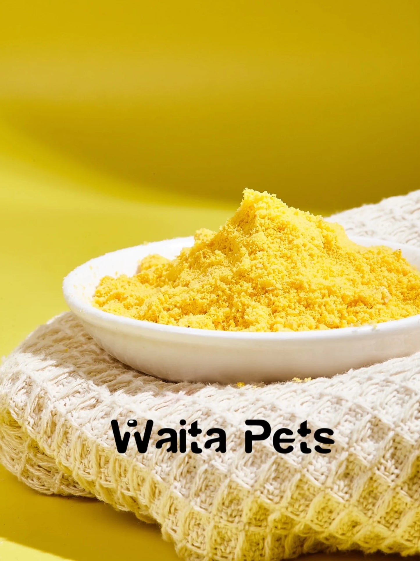 Yellow powder in a white bowl on a textured surface with a yellow background, branded 'Waita Pets'.