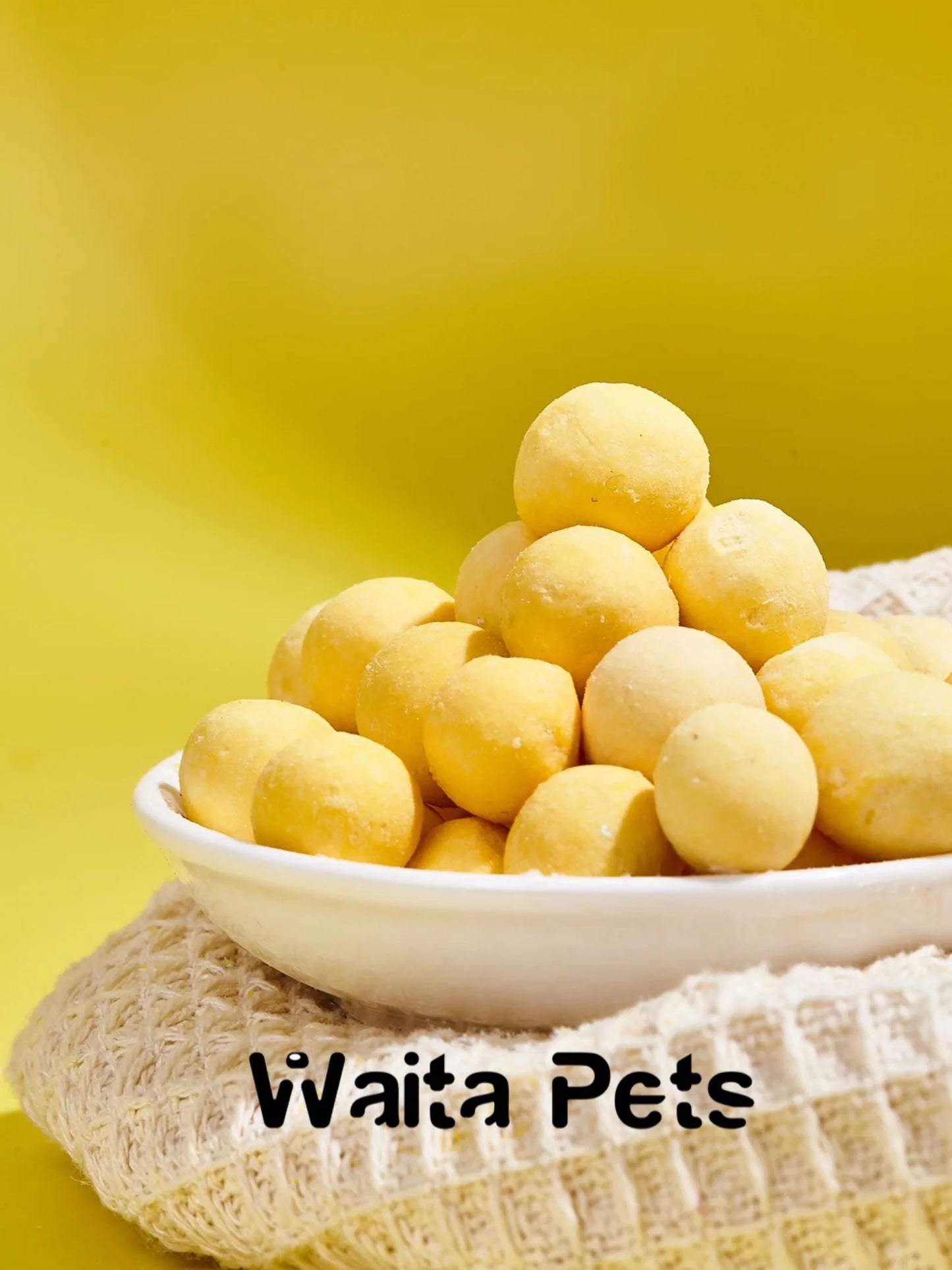 White bowl filled with yellow pet treats on a yellow background with 'Waita Pets' branding.