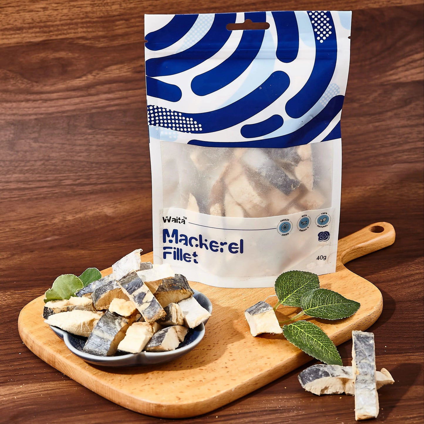 Packaged mackerel fillets on a wooden cutting board with a wooden background