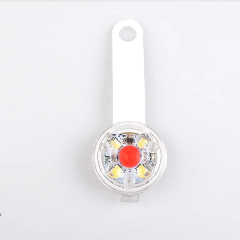 Small round light with a red center on a white background