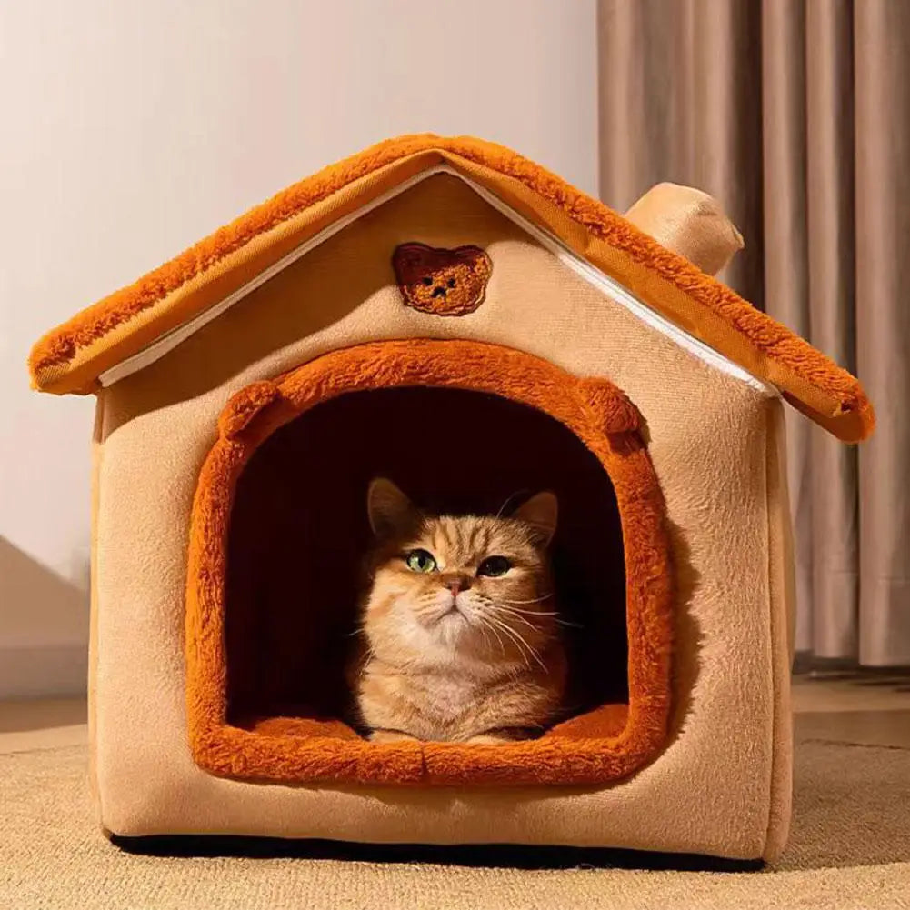 Cat inside a cozy pet house with a teddy bear on top