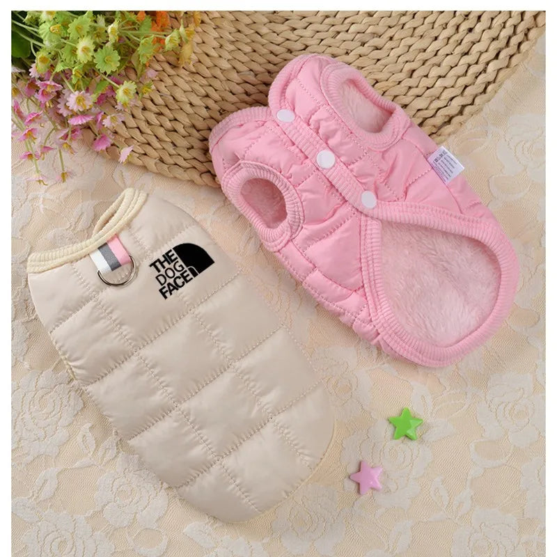 Pink slippers and beige quilted bag on a textured surface with decorative elements.