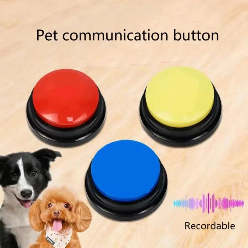 Three colorful pet communication buttons with a dog and a doggy toy in the background on a wooden surface.