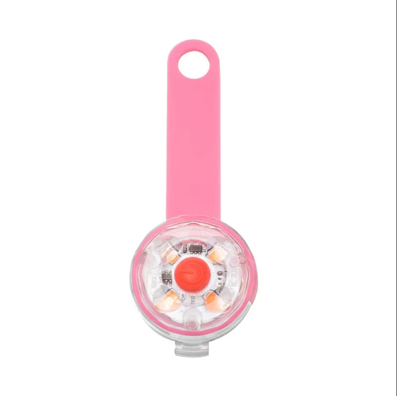 Pink and clear device with a red button on a white background