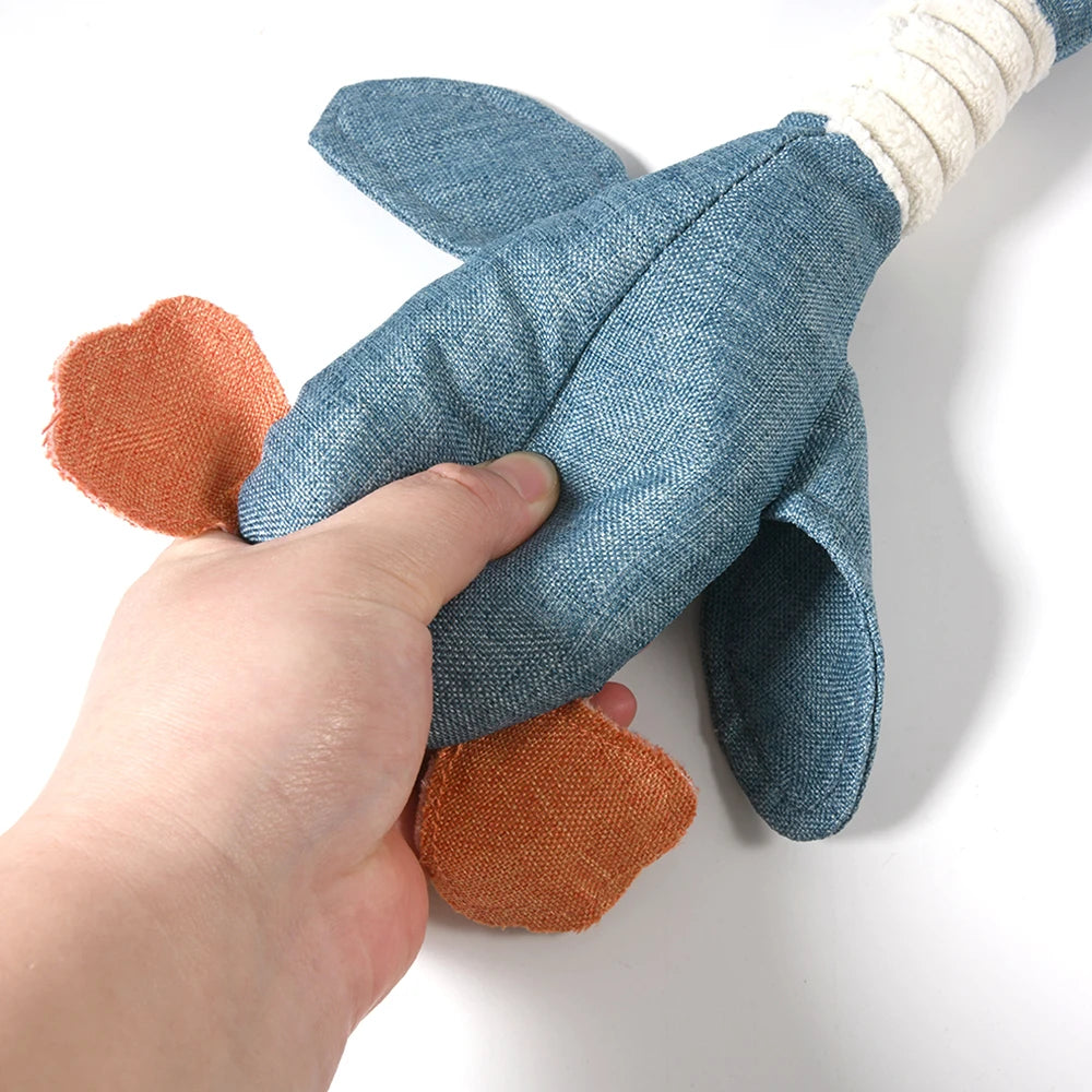 Hand holding a blue and orange plush toy on a white background