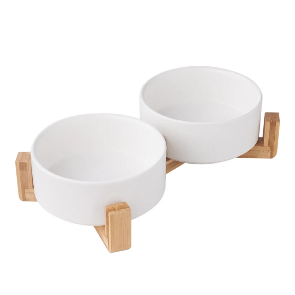 Two white bowls on a wooden stand against a white background