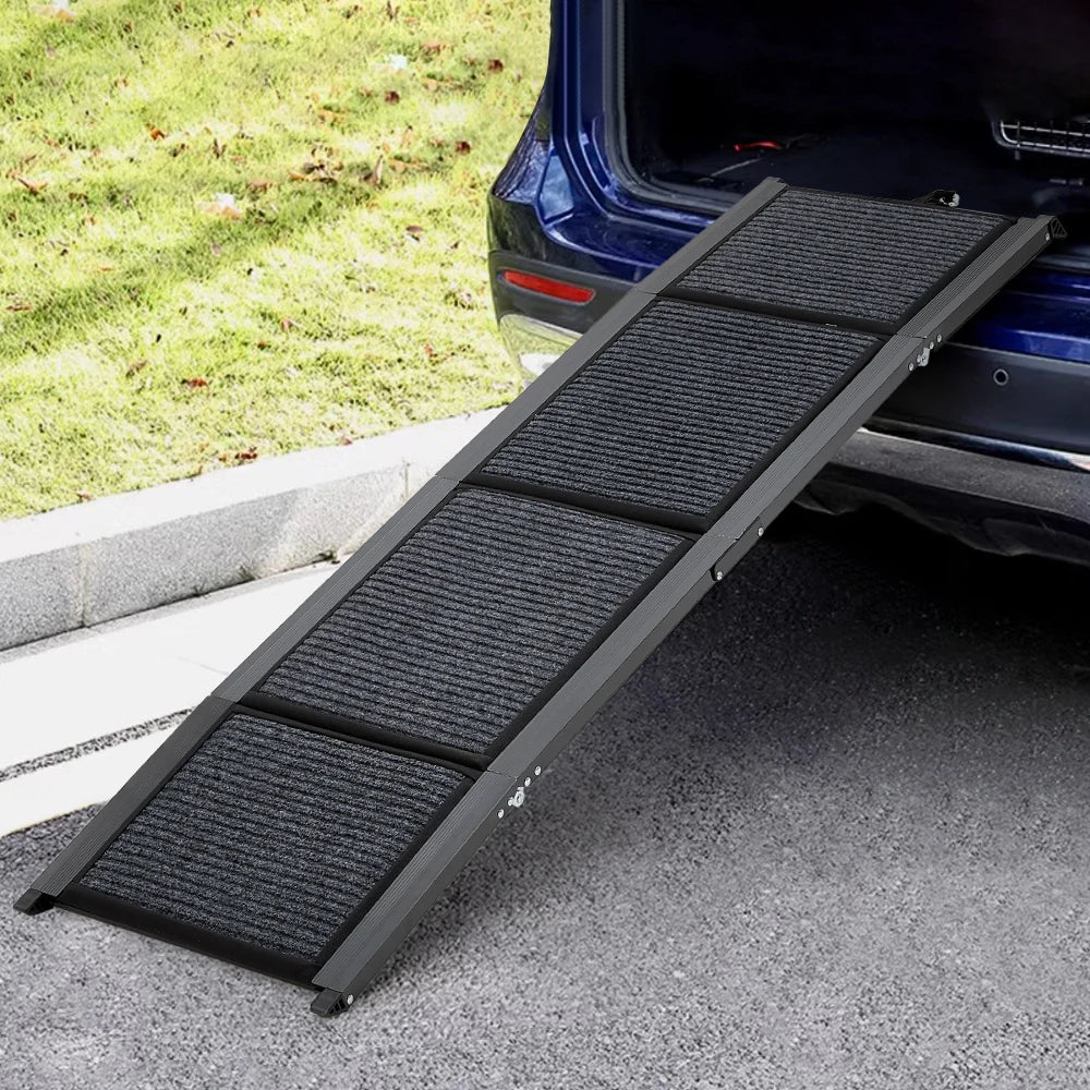 Black pet ramp in front of an open car trunk on a driveway.