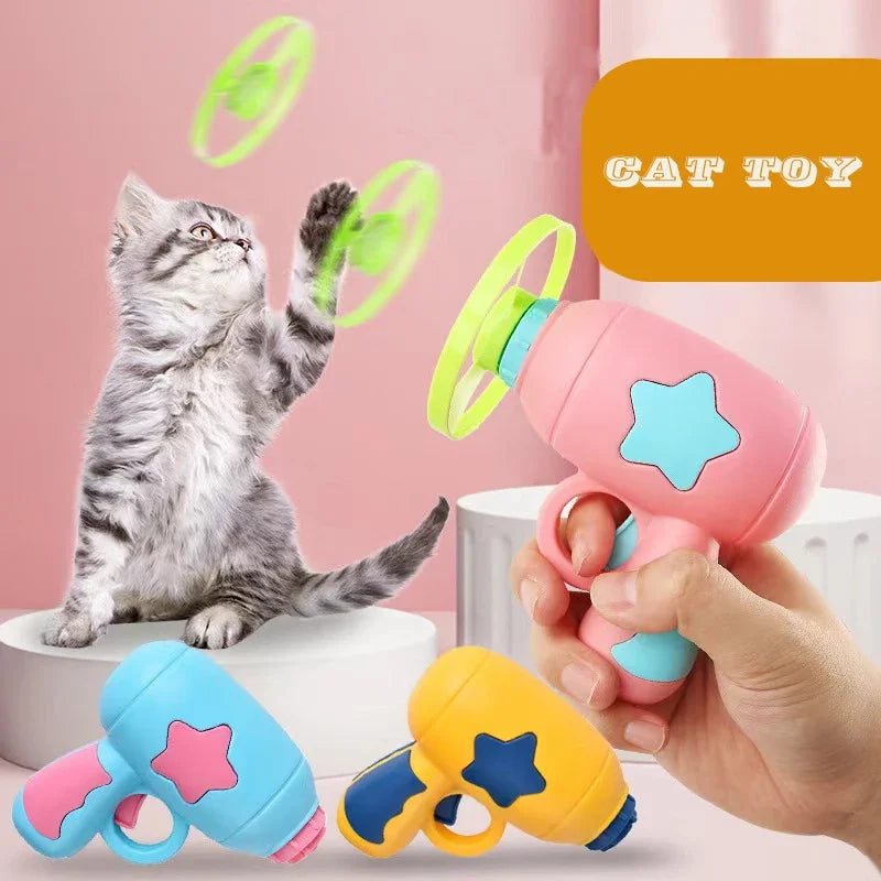 Cat toy with colorful design held by a hand, with a cat playing with it on a pink background.