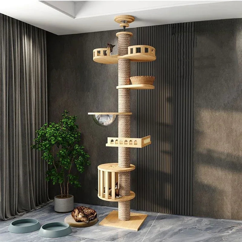 Wooden cat tree with multiple levels and shelves in a room with gray walls and a plant.