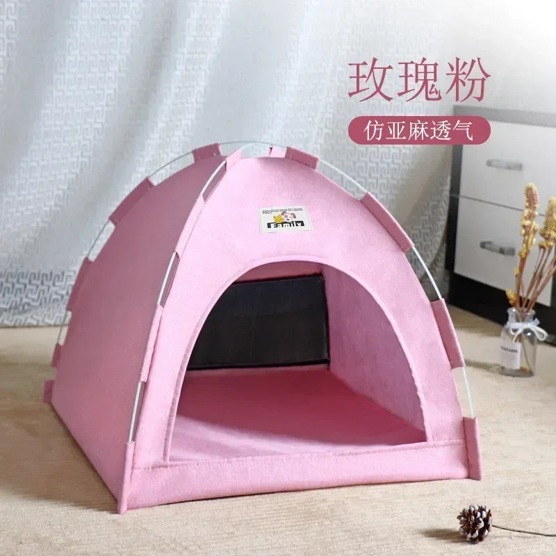 Pink pet tent on a light wooden floor with a white textured wall in the background.