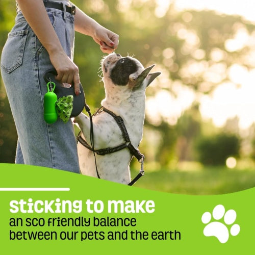 Person walking a dog with a green device, set against a blurred outdoor background.