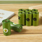 Green rolls of pet waste bags with paw prints on a wooden surface