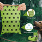 Green dog waste bags with paw pattern held by a hand, shown with a dog in the background.