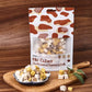 Packaged dog food mix cubes on a wooden cutting board with a wooden background