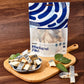 Packaged mackerel fillets on a wooden cutting board with a wooden background