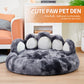 Gray paw-shaped pet bed on a wooden floor with a modern living room background.