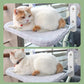 Two cats relaxing on a pet hammock attached to a window.