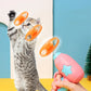 Cat playing with a pink toy held by a hand against a colorful background