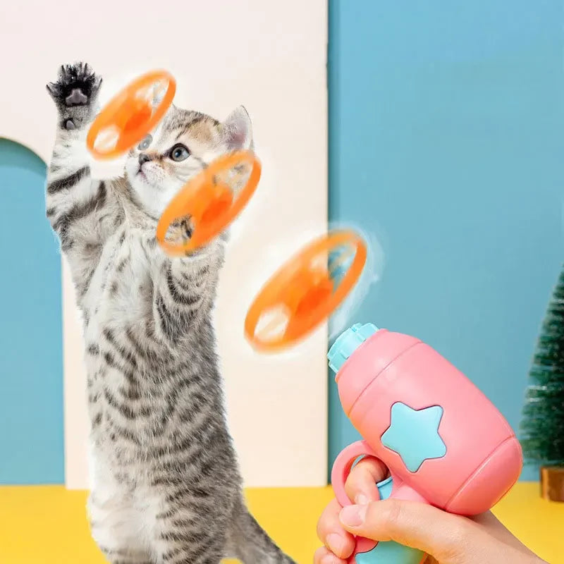 Cat playing with a pink toy held by a hand against a colorful background