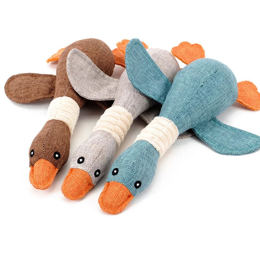 Three toy ducks in brown, gray, and blue on a white background