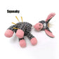 Gray and pink plush toy with a squeaky mechanism on a white background