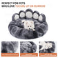 Gray paw-shaped pet bed with a white dog inside, featuring text about the product's benefits.