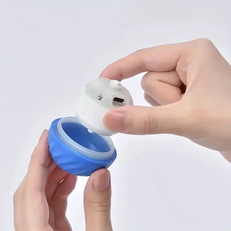 Hand holding a small blue and white container with a lid on a light gray background