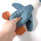 Hand holding a blue and orange plush toy on a white background