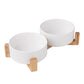 Two white bowls on a wooden stand against a white background
