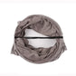 Brown scarf draped over a white mannequin head on a white background