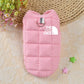Pink dog coat with 'The Dog Face' logo on a textured surface with flowers and stars.