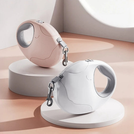 Two pet retractable leashes, one pink and one white, on a neutral background.